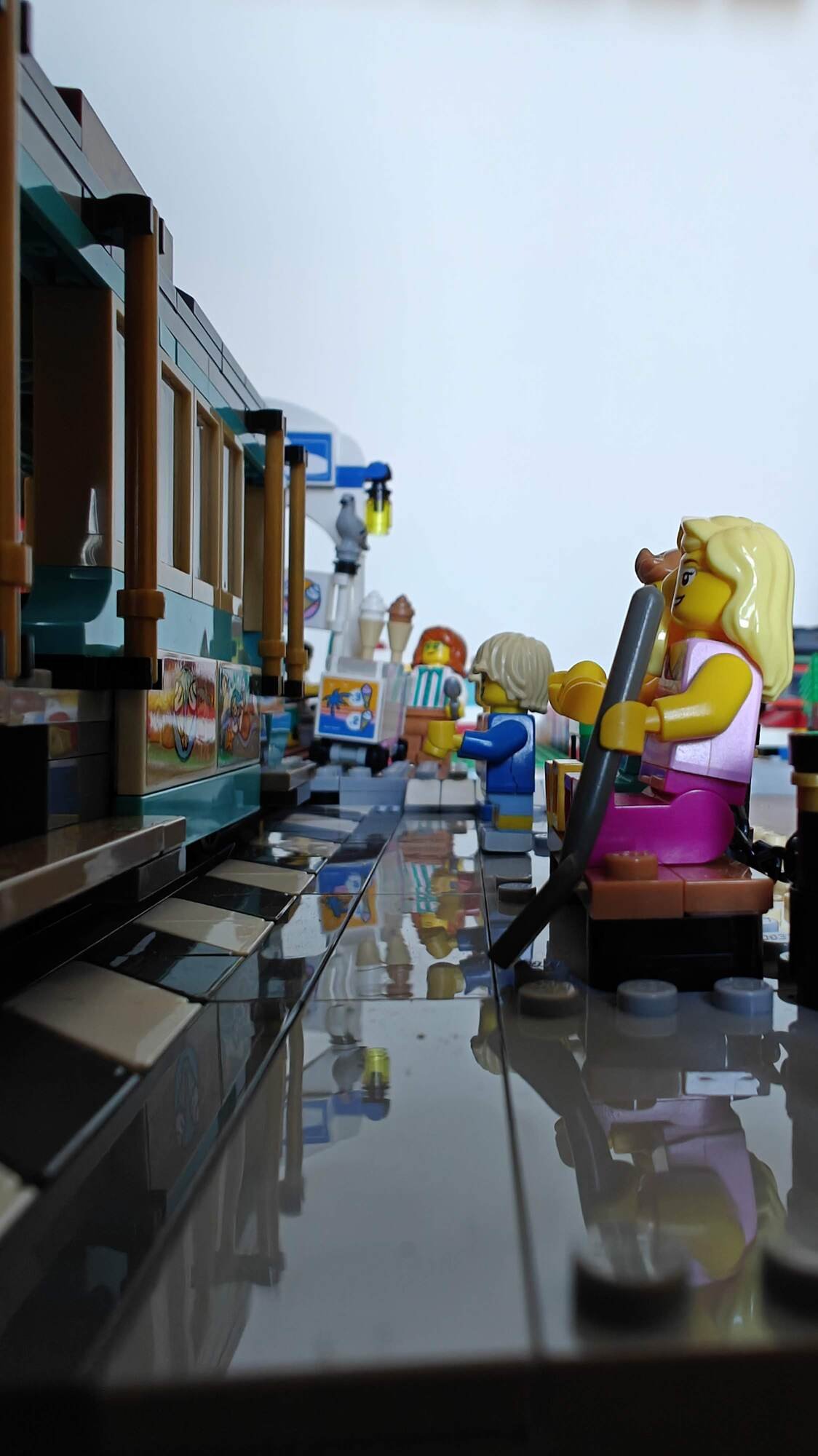 Minifigures sit and stand while waiting for the streetcar