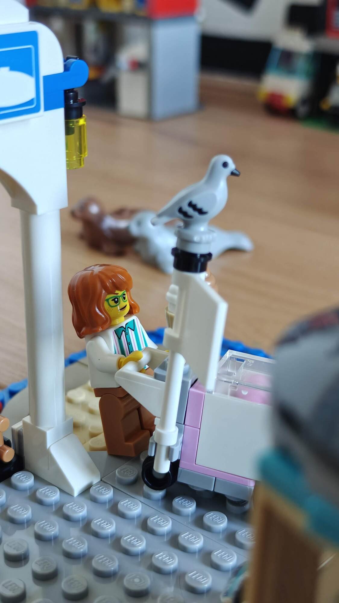A minifigure with an ice cream cart and a pigeon perched on the cart’s flag