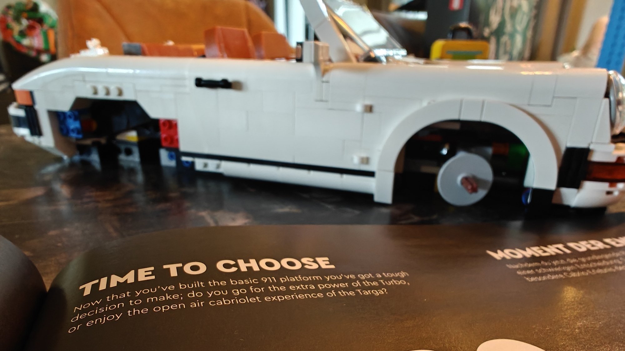 El folleto abierto muestra en texto la elección que debes hacer como constructor, la versión Turbo o Targa del Porsche
