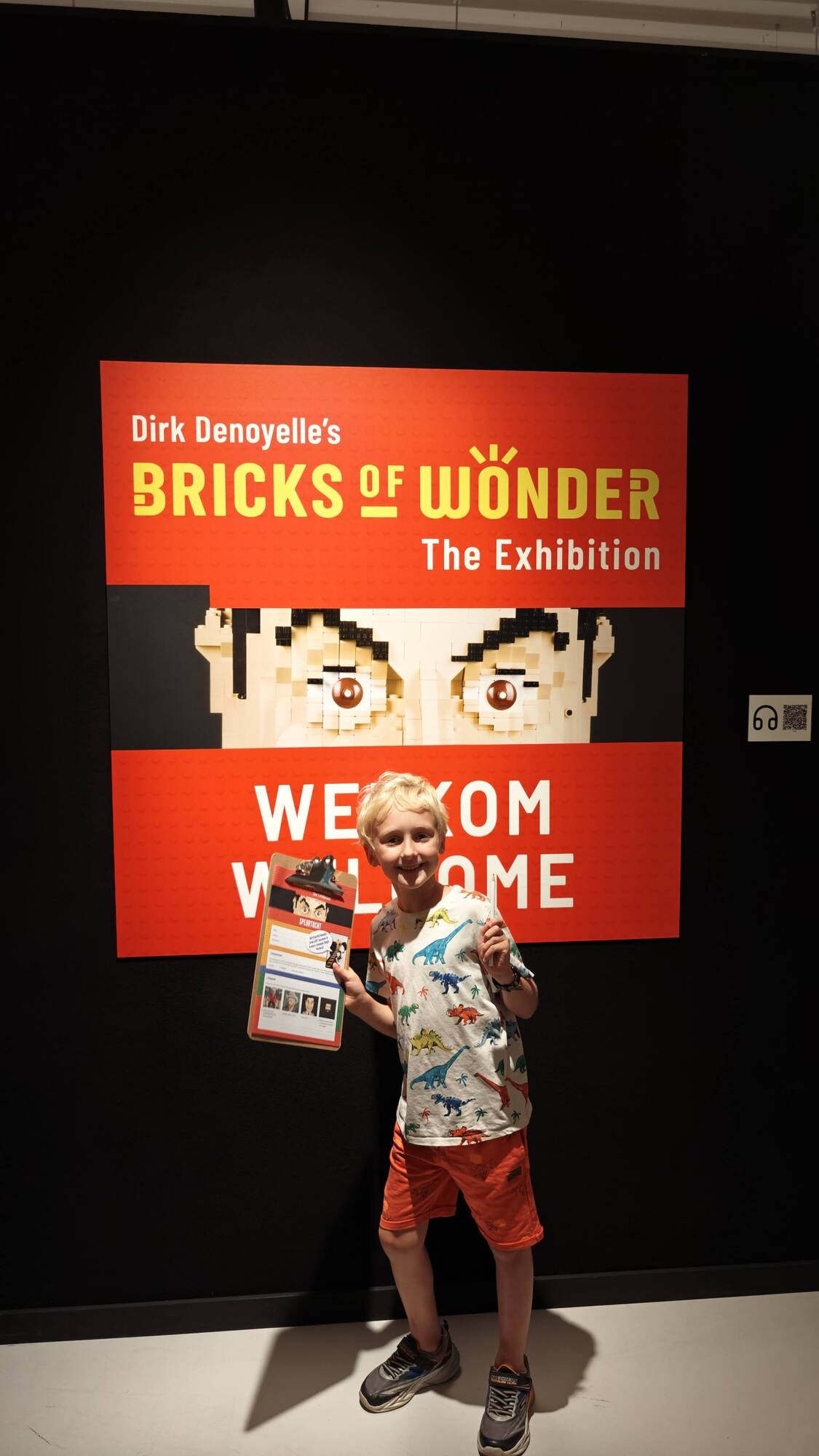 Mein Sohn posiert vor dem Eingang mit einem Ausstellungsschild