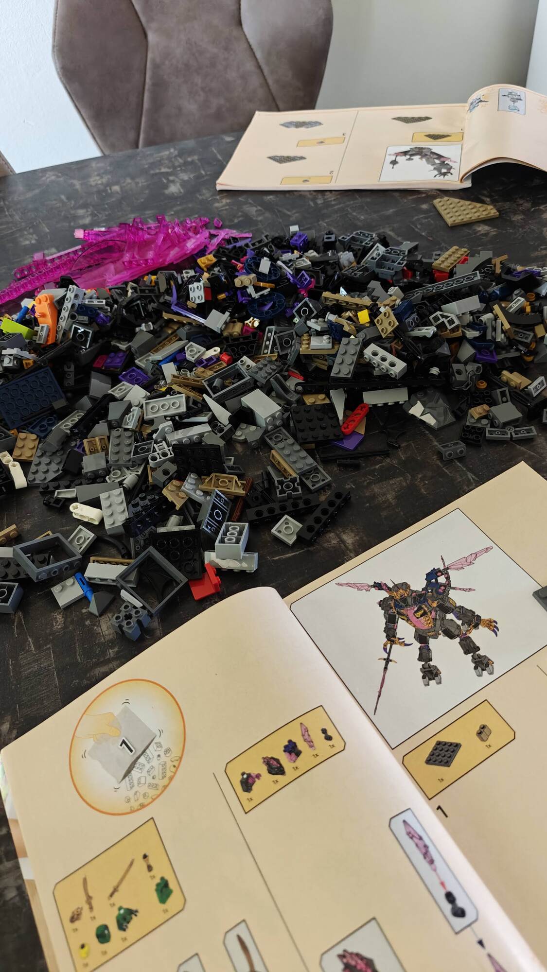 De boekjes van beide sets liggen open met in het midden een grote stapel LEGO® onderdelen van beide sets door elkaar