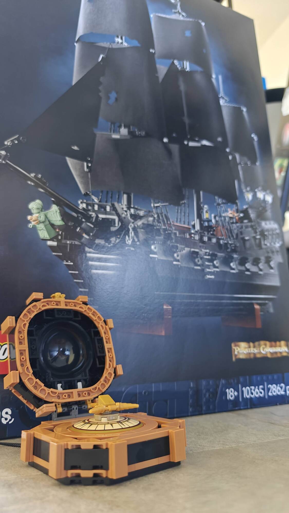 A bússola de Jack Sparrow construída em vista com a caixa do navio pirata ao fundo