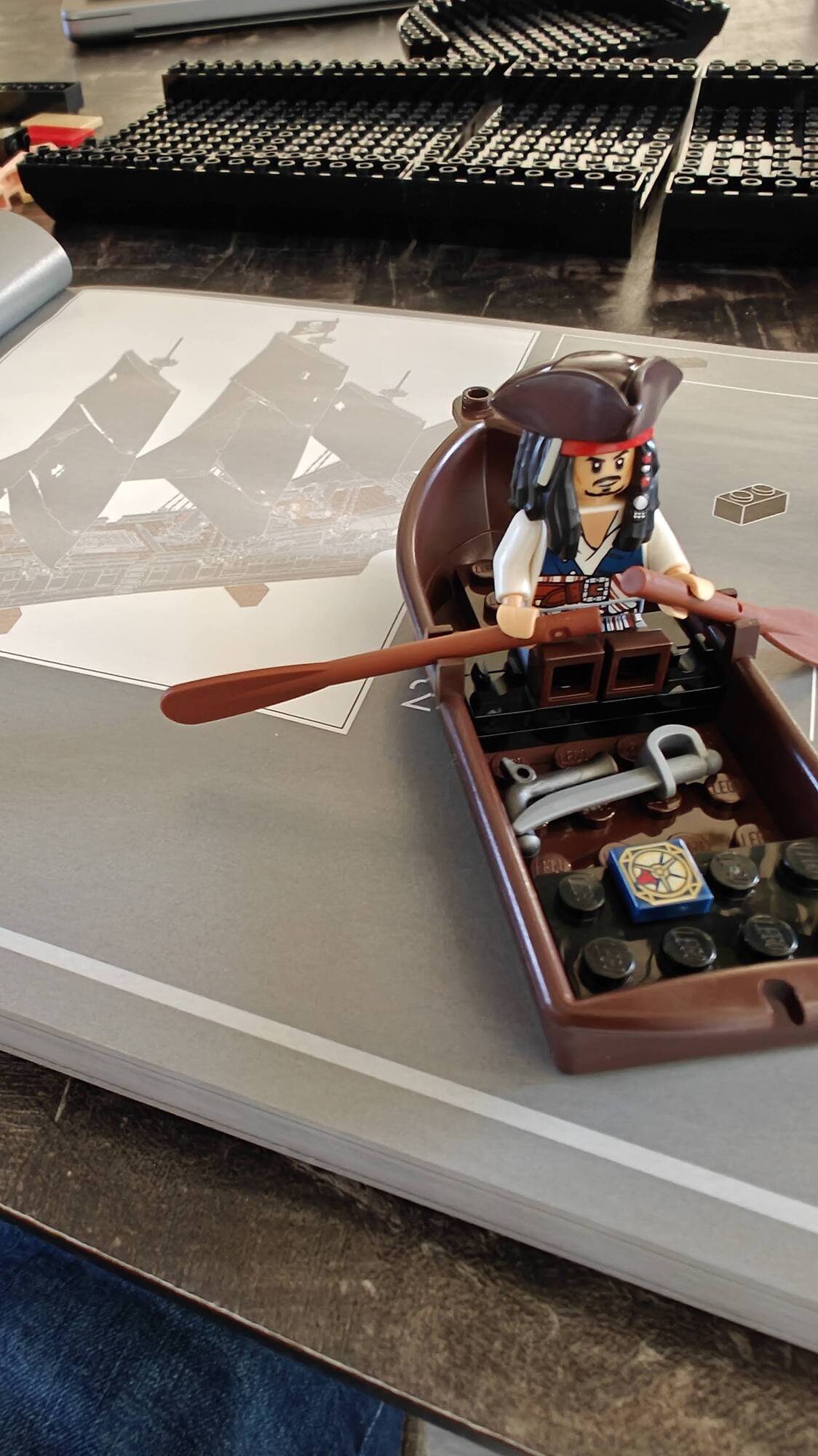 Minifig de Jack Sparrow em um pequeno barco a remo sobre as instruções de construção