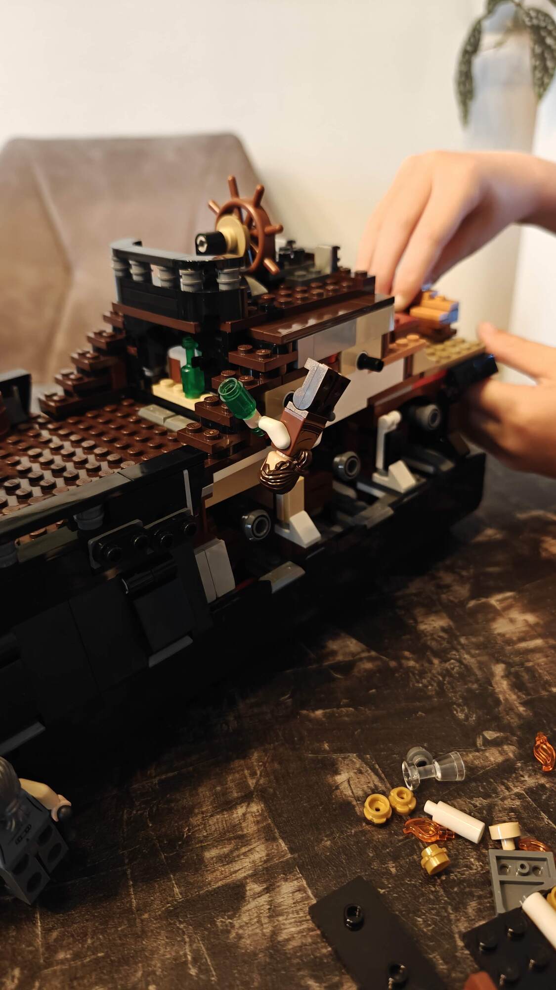 O navio em estado meio construído com uma minifig pendurada de cabeça para baixo no corrimão