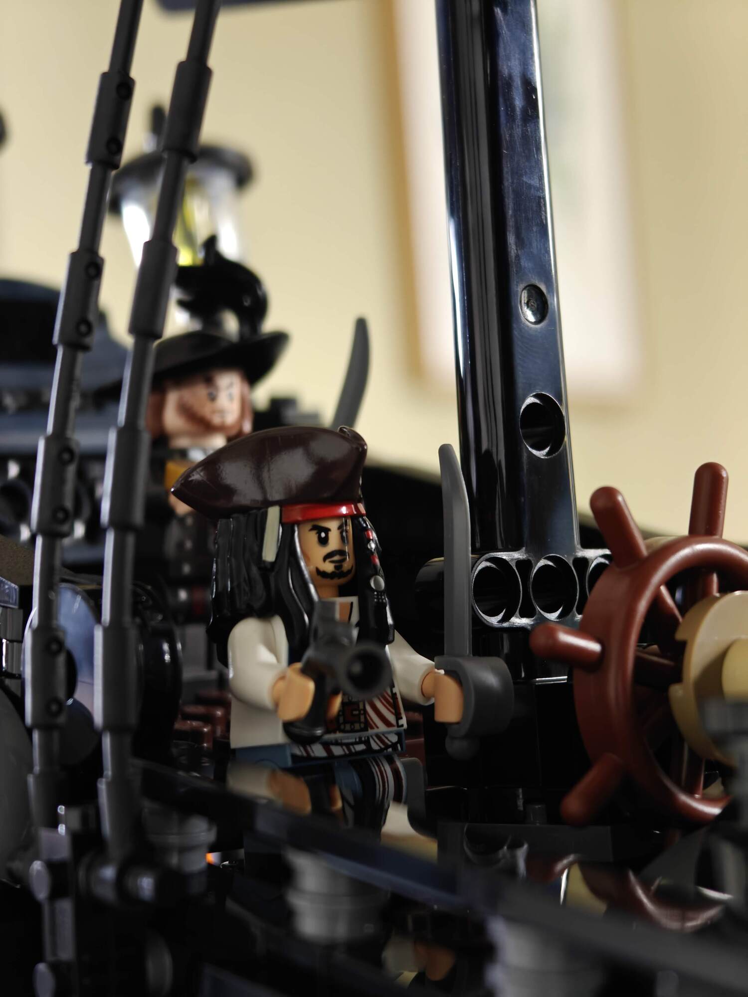 Minifig em close-up de Jack Sparrow ao lado do leme do navio