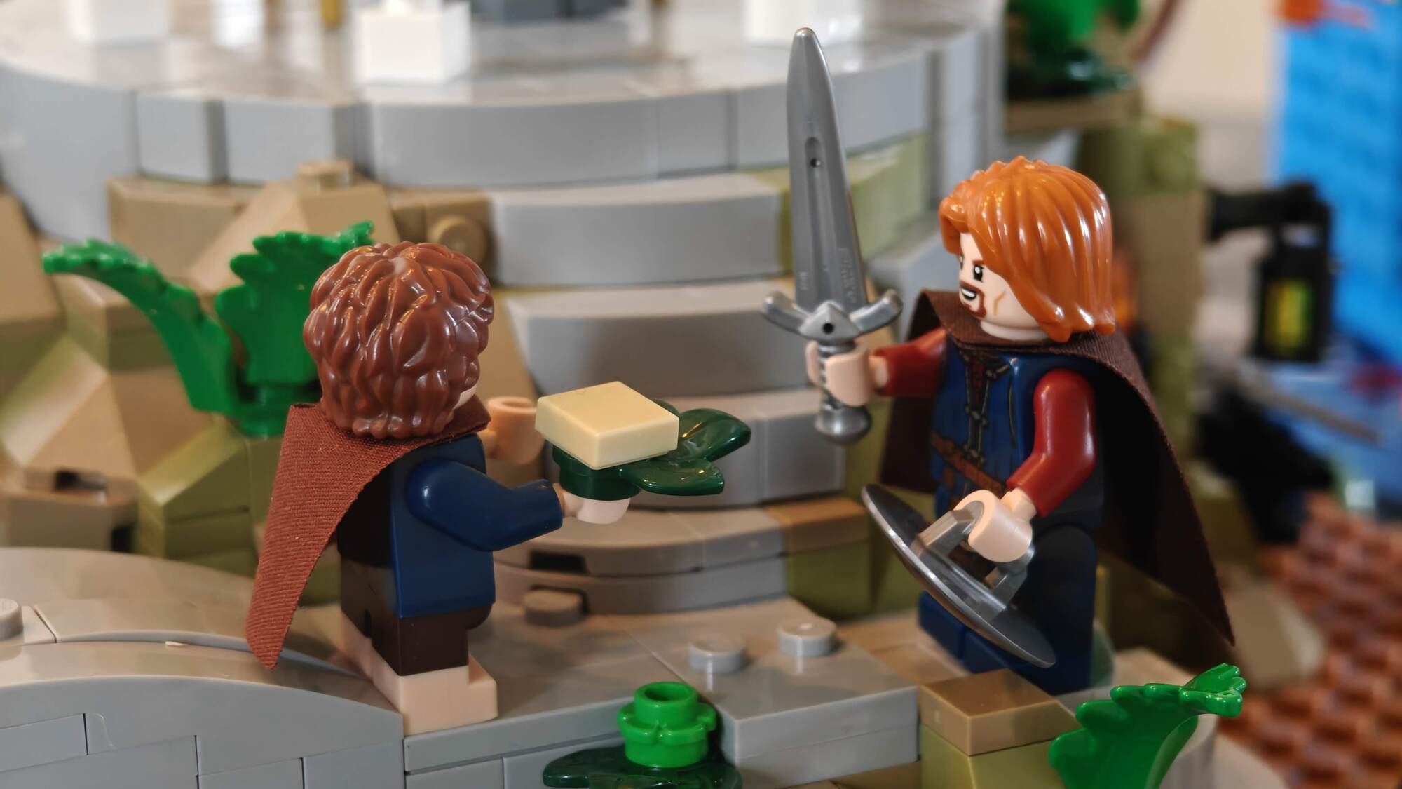 Pippin segura massa e fala com Boromir que segura seu escudo e espada na ponte