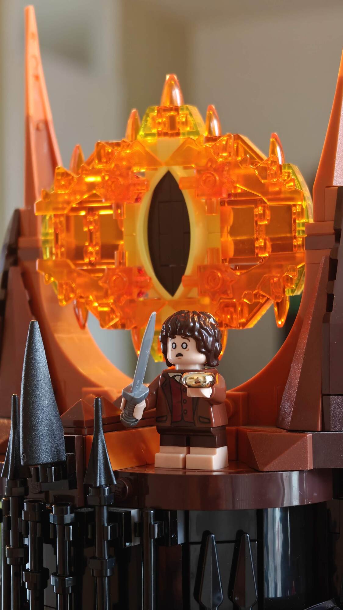 Frodo está com o anel na mão diante do olho de Sauron