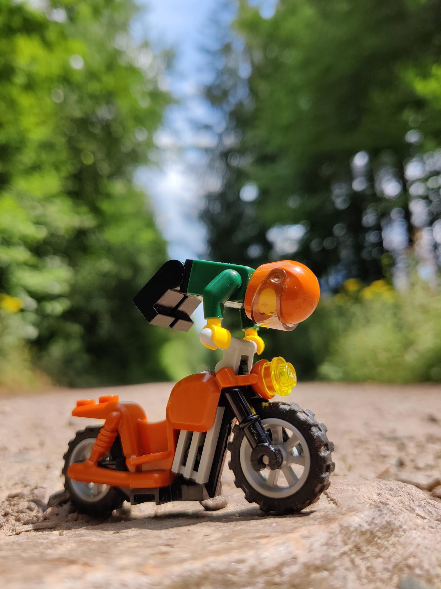 Minifig-Stunt auf einem Motorrad auf einem Waldweg
