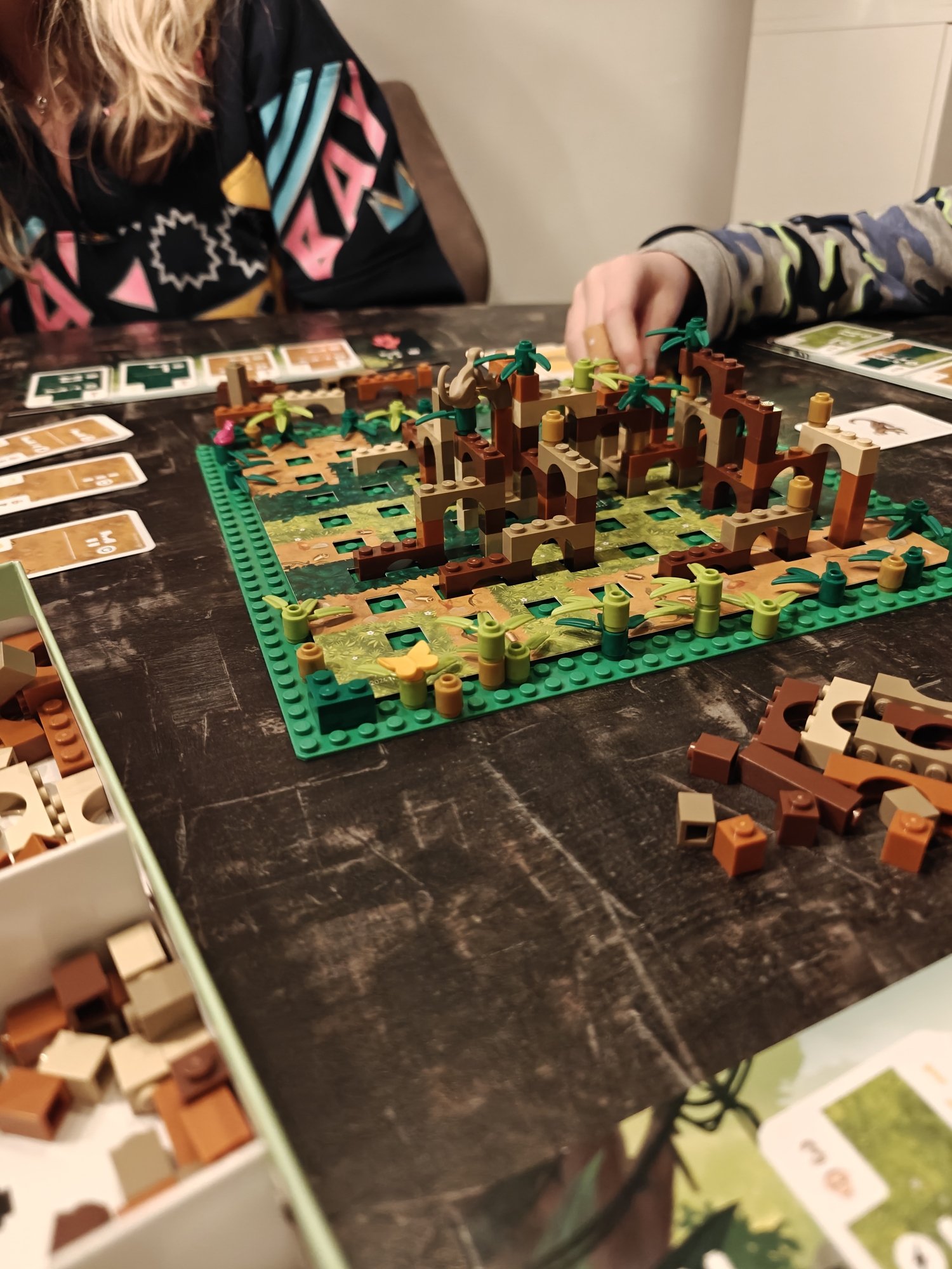 Plateau avec des briques LEGO entouré de pièces supplémentaires et de cartes de construction