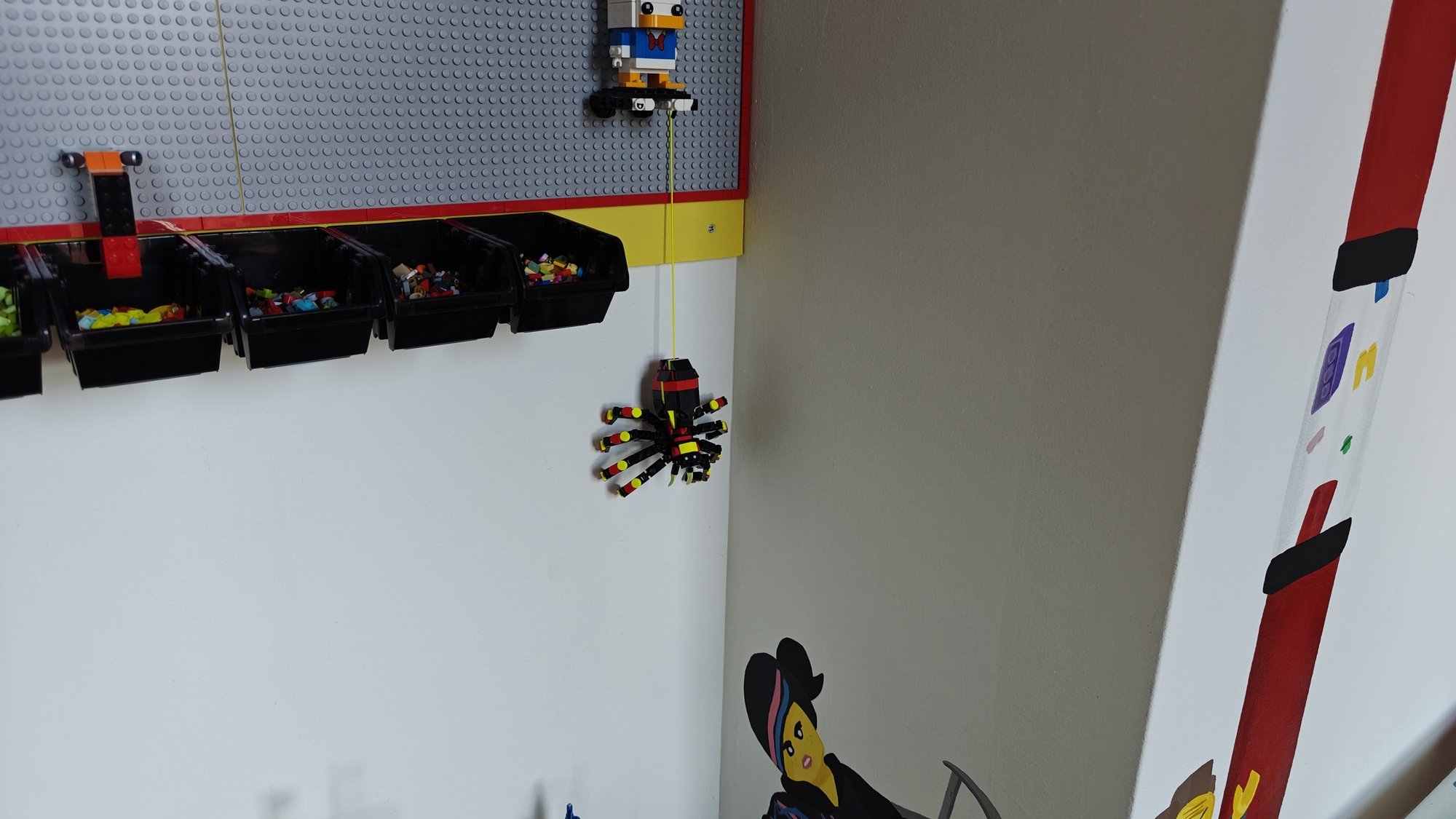 The LEGO® Brick Wall with a focus on the spider dangling on a string below the wall