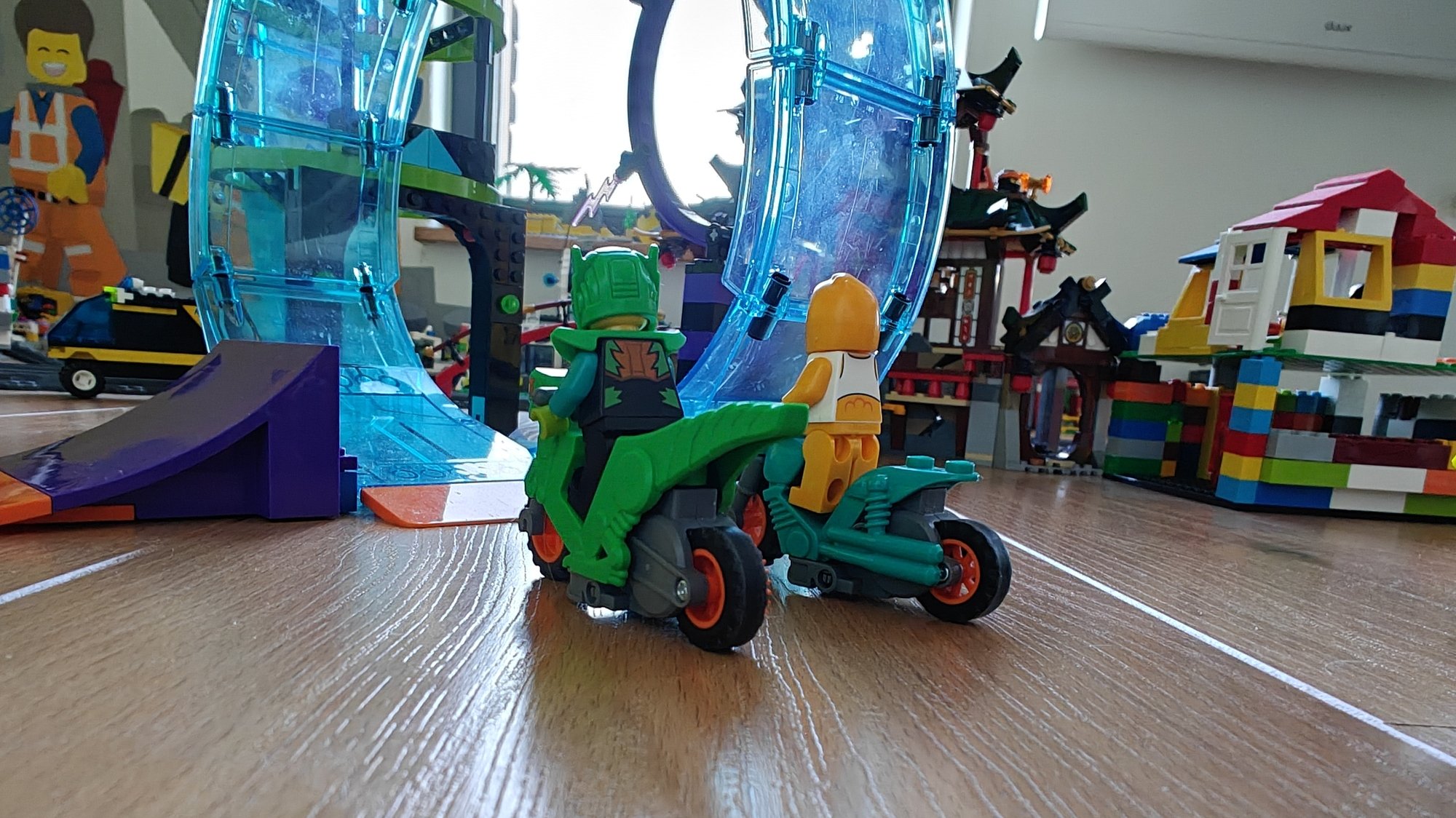 Two motorbikes with minifigs lined up to take on the stunts in the background